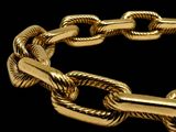 an image of a close up of a gold bracelet on a black background