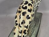 a figurine of a leopard sitting on a base