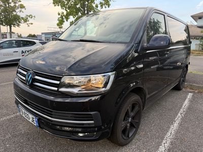 La camionnette noire est garée sur un parking, à côté d'autres voitures.