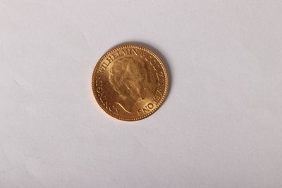 gros plan d'une pièce d'or sur une surface blanche