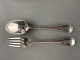 two silver spoons and a fork on a gray surface