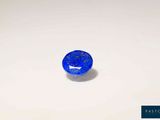 a blue oval sapphire stone on a white surface