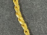 a close up of a gold necklace on a gray surface