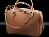 tan leather handbag on a black background with a black background