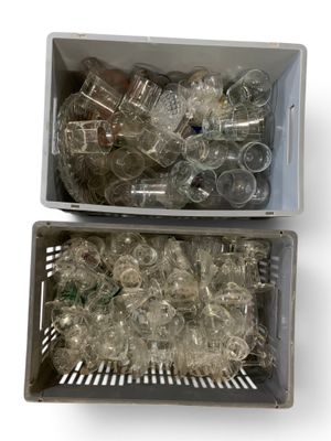 deux bacs remplis de bouteilles en plastique vides posés sur une surface blanche