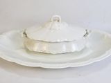a white plate with a lid on it on a white table