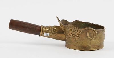 an old brass pot with a wooden handle on a white surface