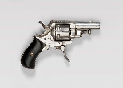 un vieux revolver argenté avec une crosse noire sur fond blanc