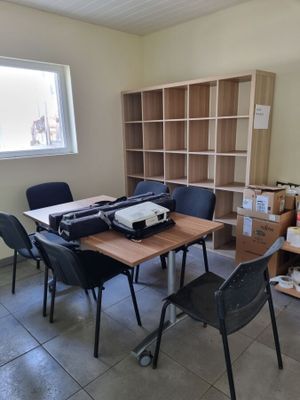 une pièce avec une table, des chaises et une imprimante dessus