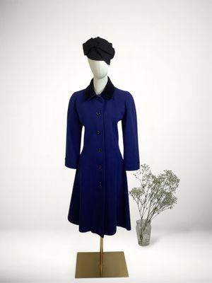 blue coat with black collar and cuffs on a mannequin base