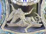 a clock that has a picture of a winged figure on it