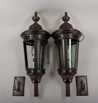 pair of antique style outdoor wall lights mounted on a white wall