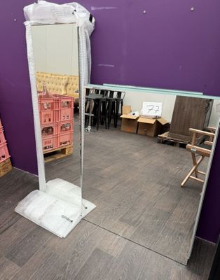 a mirror in the middle of a room with a purple wall