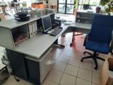 a desk with two computers and a chair in a room
