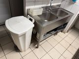 une poubelle située à côté d'un lavabo dans des toilettes publiques