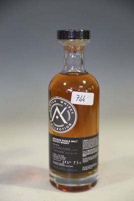 a bottle of whisky sitting on top of a white table