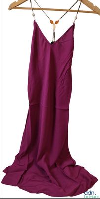 une robe violette suspendue à un cintre sur fond blanc
