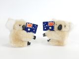 une paire de koalas en peluche tenant des drapeaux australiens sur fond blanc