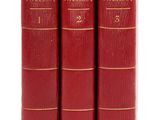 trois livres rouges superposés sur une surface blanche