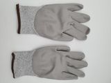 two pairs of gray gloves on a white surface