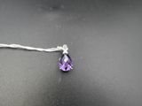 un gros plan d'un collier orné d'une pierre violette