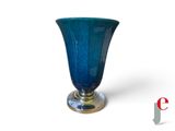 un vase en verre bleu avec un socle en argent sur fond blanc