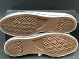 the bottom of a pair of brown and white shoes on a box
