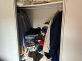 une armoire pleine de vêtements et des vêtements dans une pièce