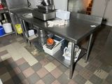 a kitchen with a table and a mixer on the counter