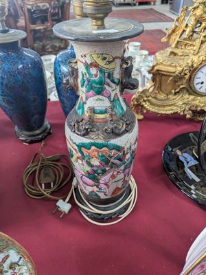 many vases and clocks on a table with a red table cloth