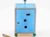 a small blue box with a green knob and a pair of scissors next to it