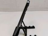 a black tablet computer sitting on a stand on a table