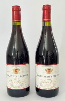 deux bouteilles de vin rouge posées l'une à côté de l'autre sur une surface blanche
