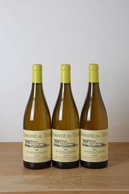 trois bouteilles de vin posées sur une table en bois