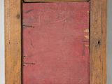 an old picture frame with a red background on a white wall