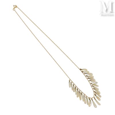 un collier en or composé d'une longue chaîne ornée d'un motif de feuilles