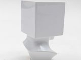 a white vase that has a white box on top of it