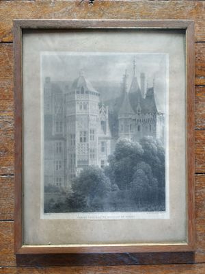 une vieille photo d'un château, dans un cadre en bois, accrochée au mur