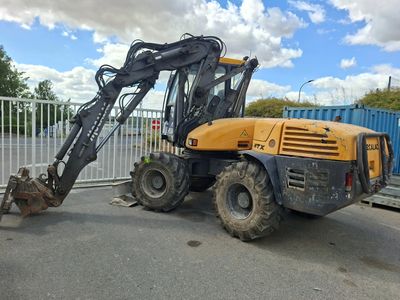 une photo d'un engin de chantier garé sur un parking