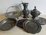 tout un tas de vieux plats et casseroles en métal posés sur une table