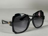 une paire de lunettes de soleil noires posée sur une surface blanche