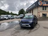 La voiture bleue est garée devant l'immeuble, sur le parking.