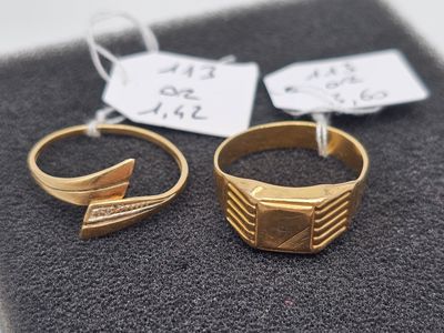 two gold rings sitting next to each other on top of a piece of cloth