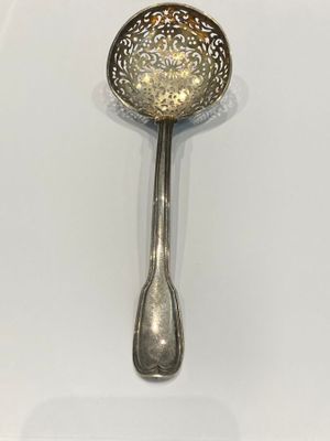 silver plated spoon on a white surface with a spoon in the middle of the spoon