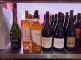 bottles of wine are lined up on a shelf in a wine shop