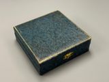une image représentant une boîte bleue posée sur une table blanche