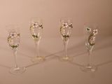quatre verres à vin décorés de fleurs, posés sur une table