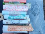 many rolls of fabric sitting on a table next to a book