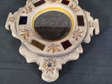 a decorative mirror on a stand with a black background