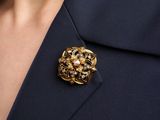 a close up of a person wearing a suit and a brooch